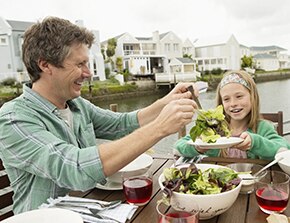 Père et fille mangeant de la salade