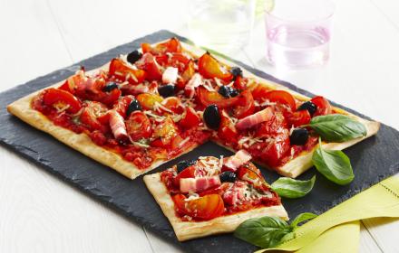 Pizza aux tomates, lardons, olives et pesto
